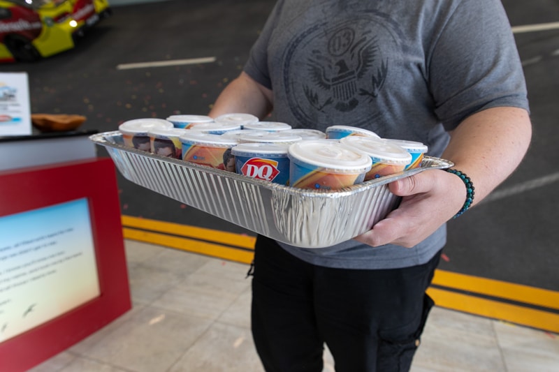 Closeup view of employee holding a tray of ice cream treats.